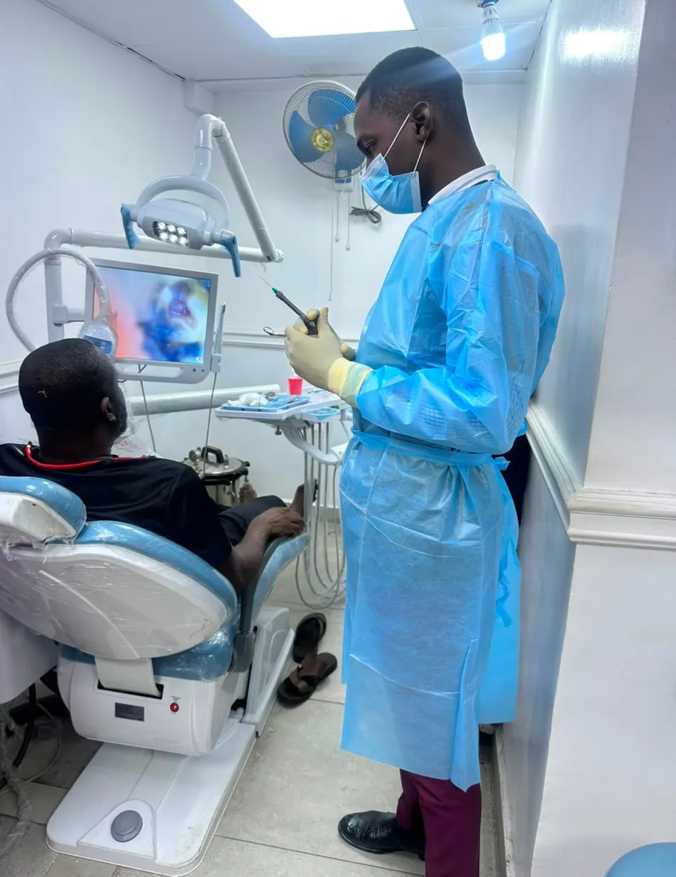 Dr. Iortyom preparing treatment for a patient in an equipped dental surgery