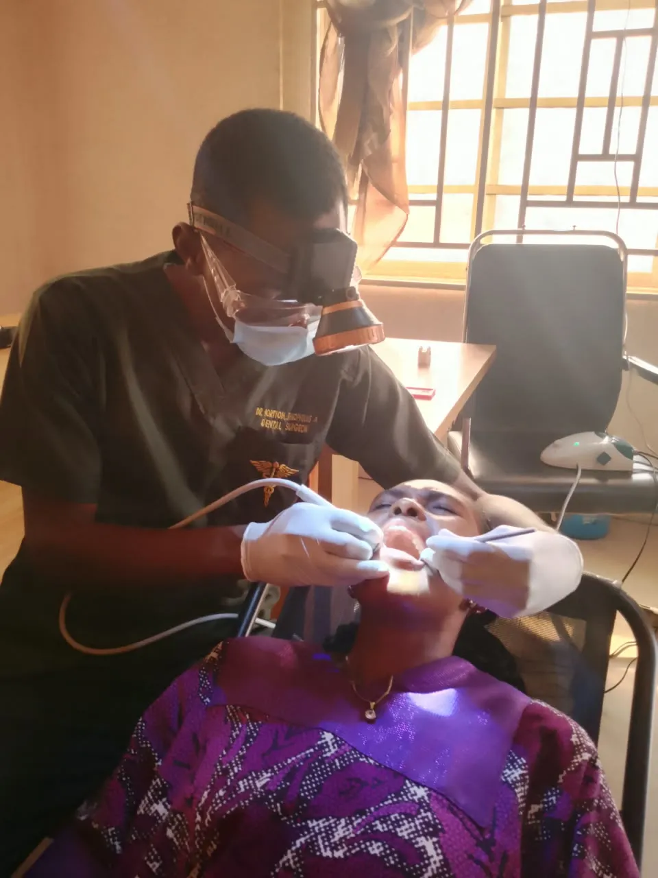 Dr. Iortyom treating a patient with portable dental equipment